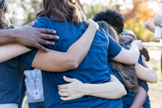 A group of people are hugging each other in a huddle.
