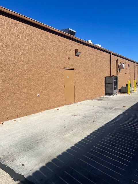 A brick building with a yellow pole in front of it