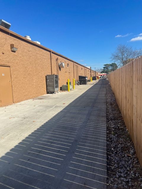A brick building with a wooden fence along the side of it