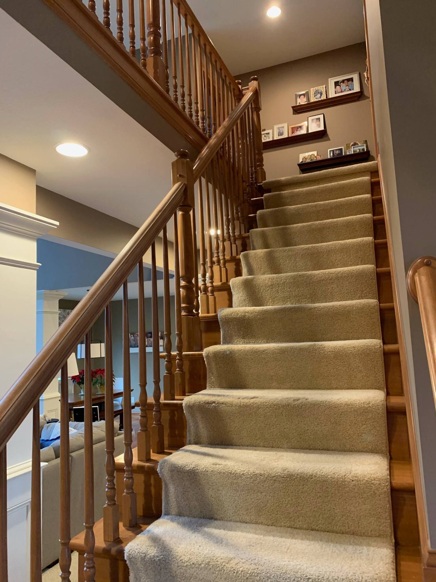A staircase with a wooden railing and carpeted steps in a house.