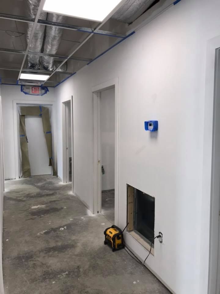 A hallway with white walls and a window in the wall.