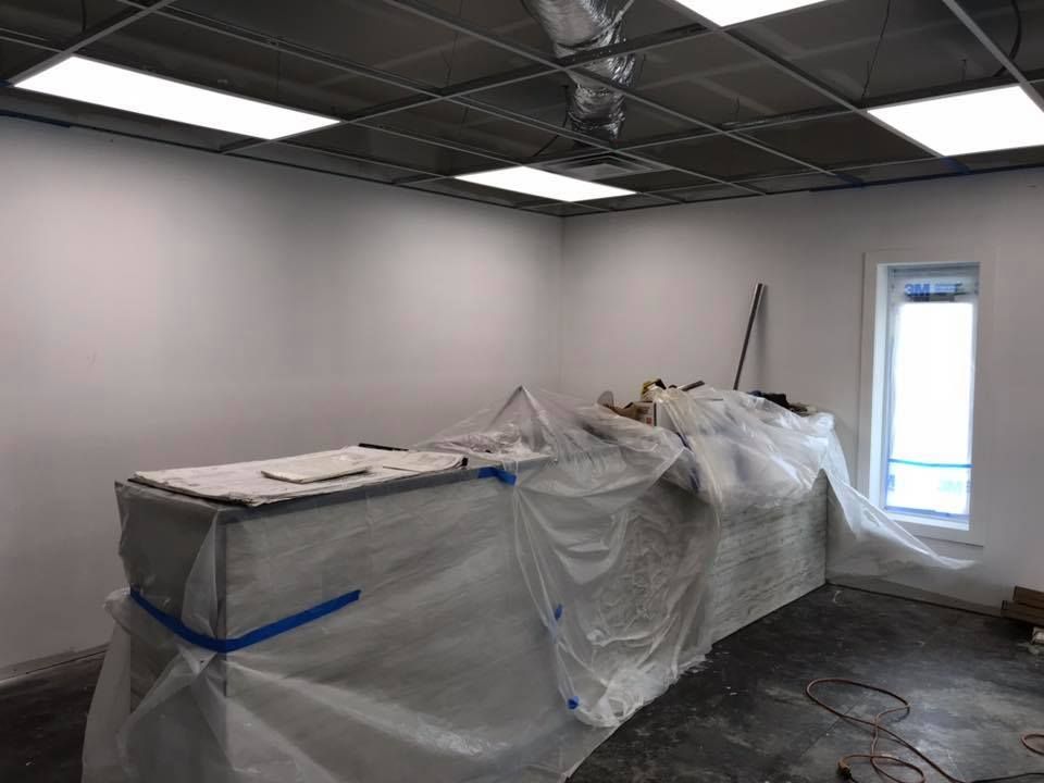 A room with a table covered in plastic and a window.