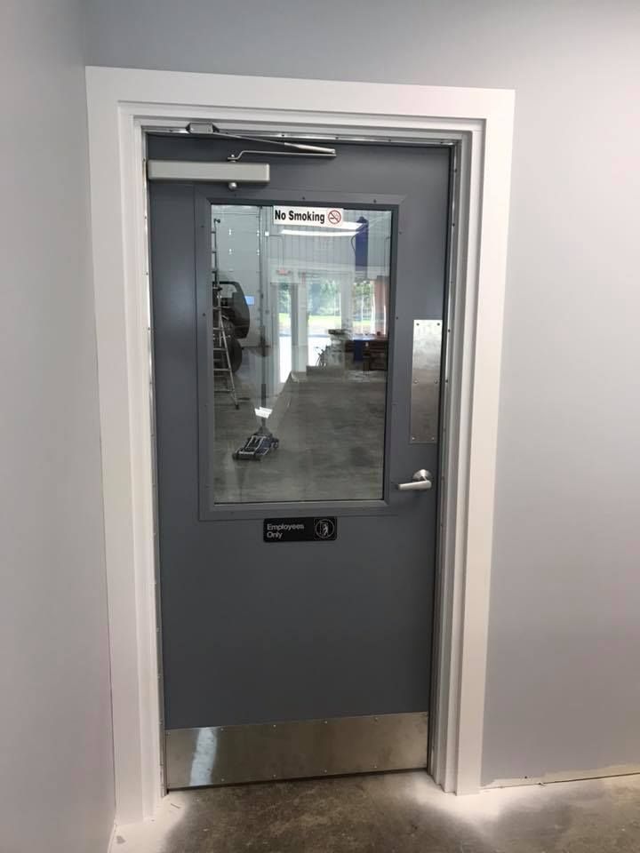 A gray door with a glass window in a room.
