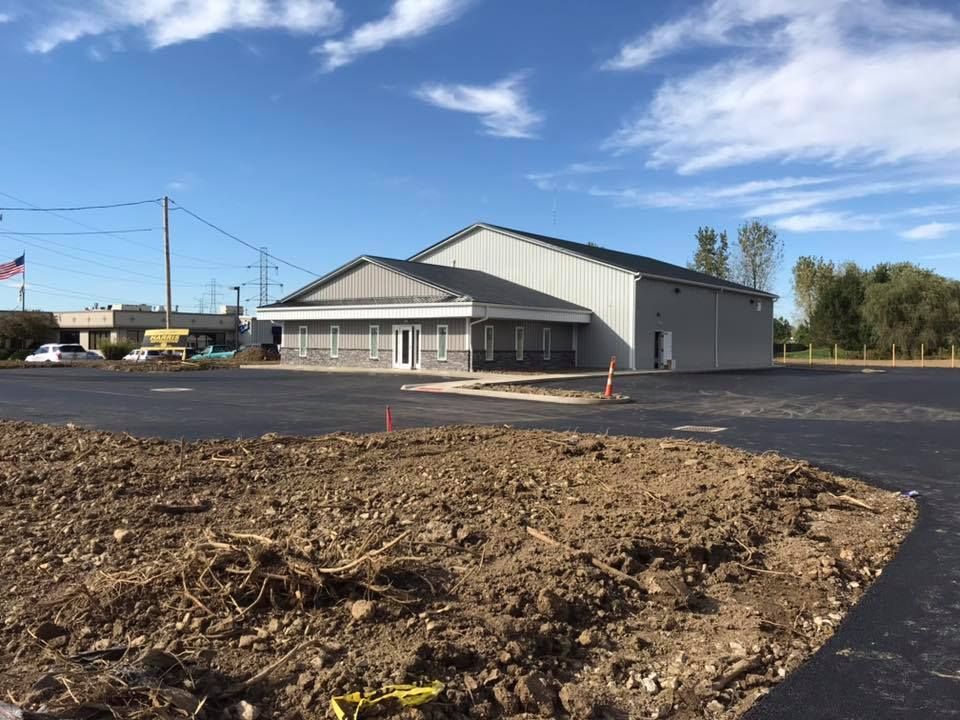 A large building is sitting in the middle of a dirt field.