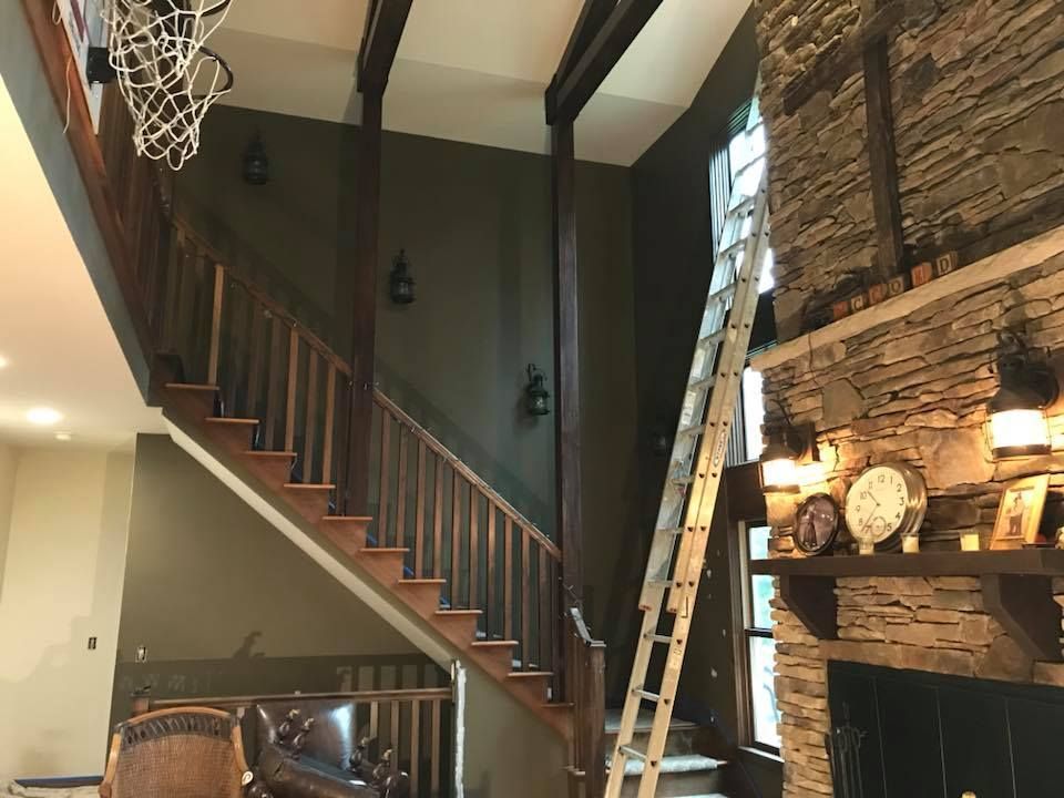 A living room with stairs , a fireplace and a basketball hoop.