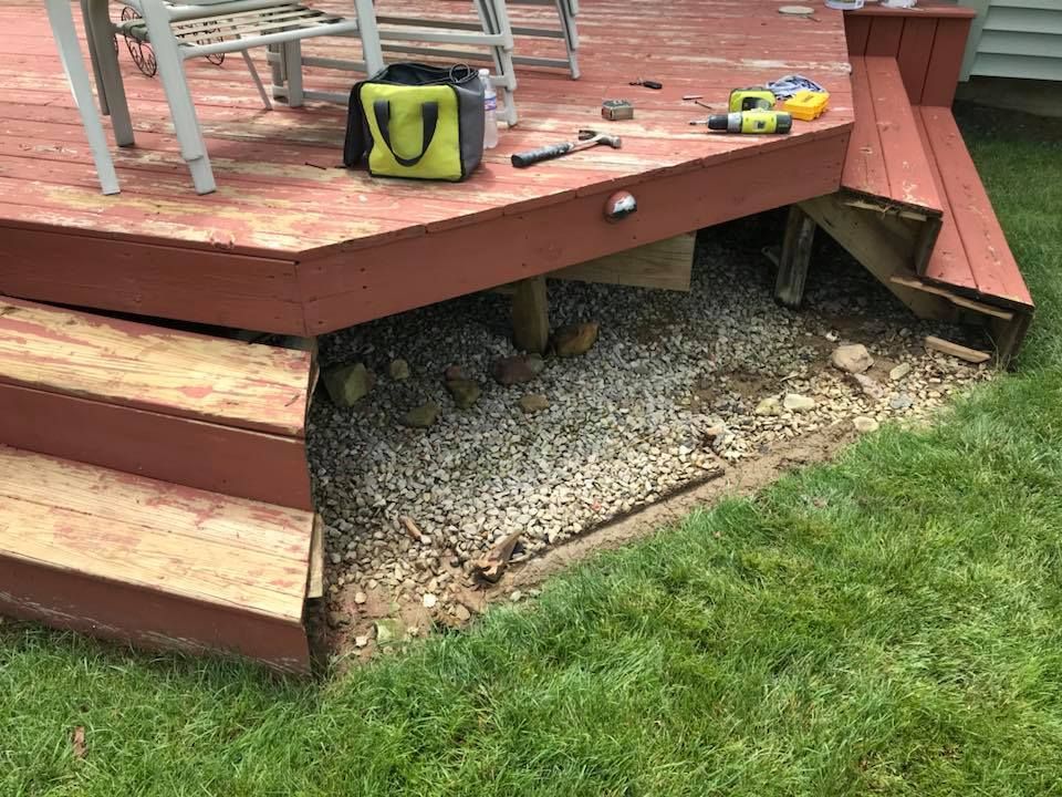 A wooden deck with stairs and a bag of tools on it.