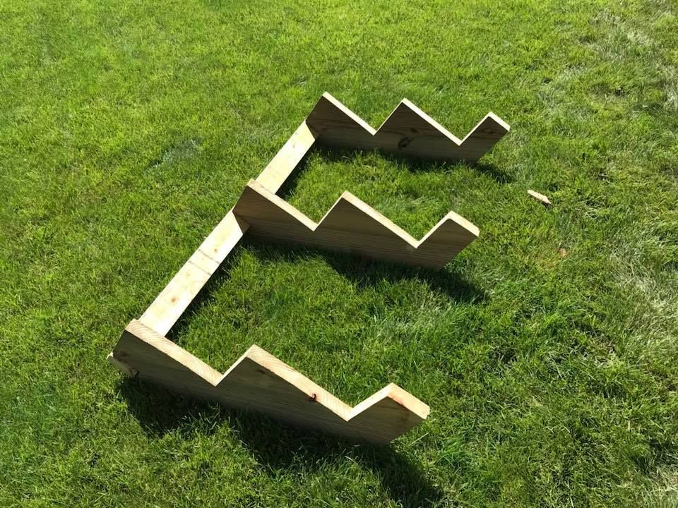 A wooden staircase is sitting on top of a lush green field.