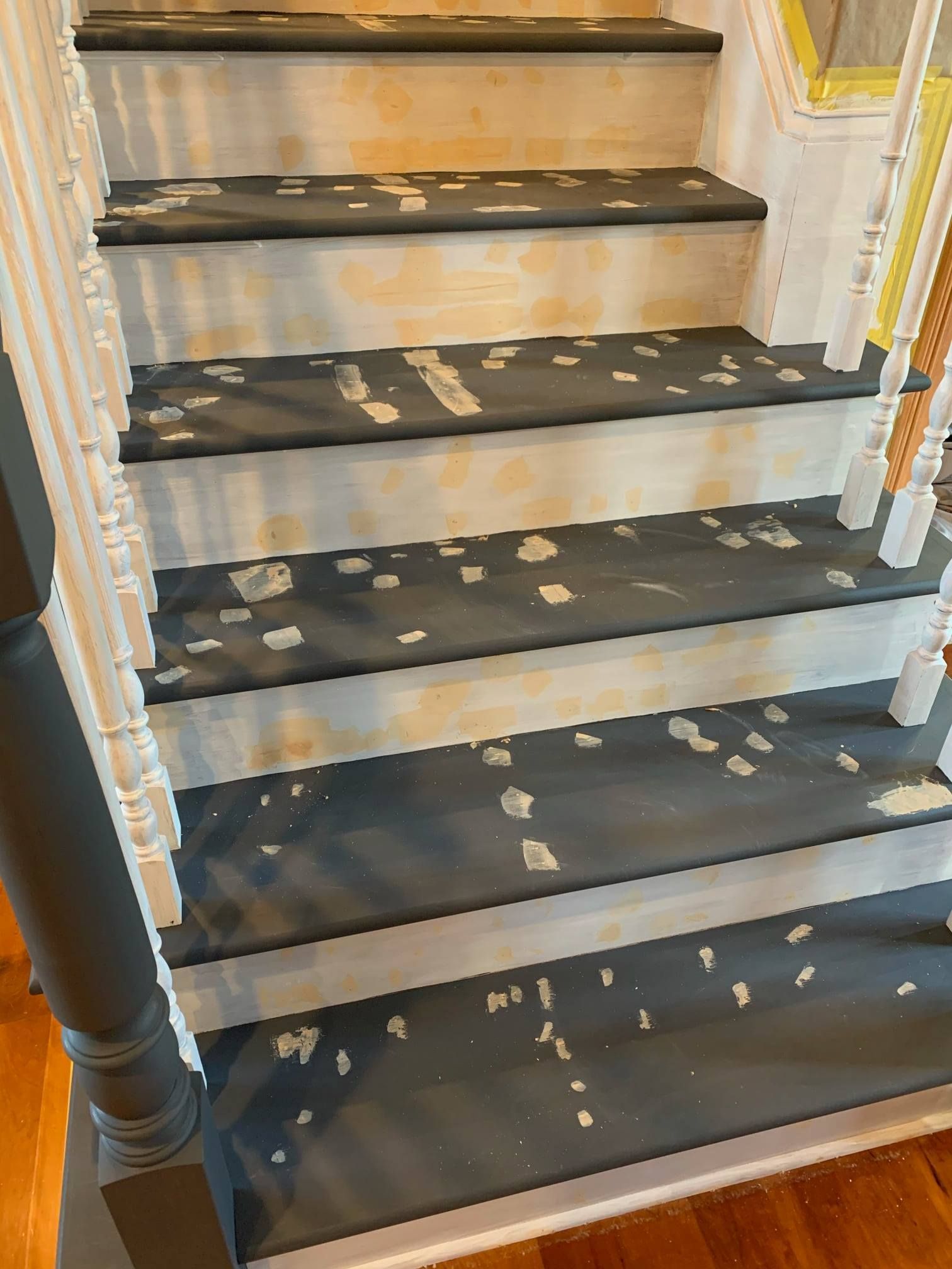 A close up of a staircase with black steps and white railing.