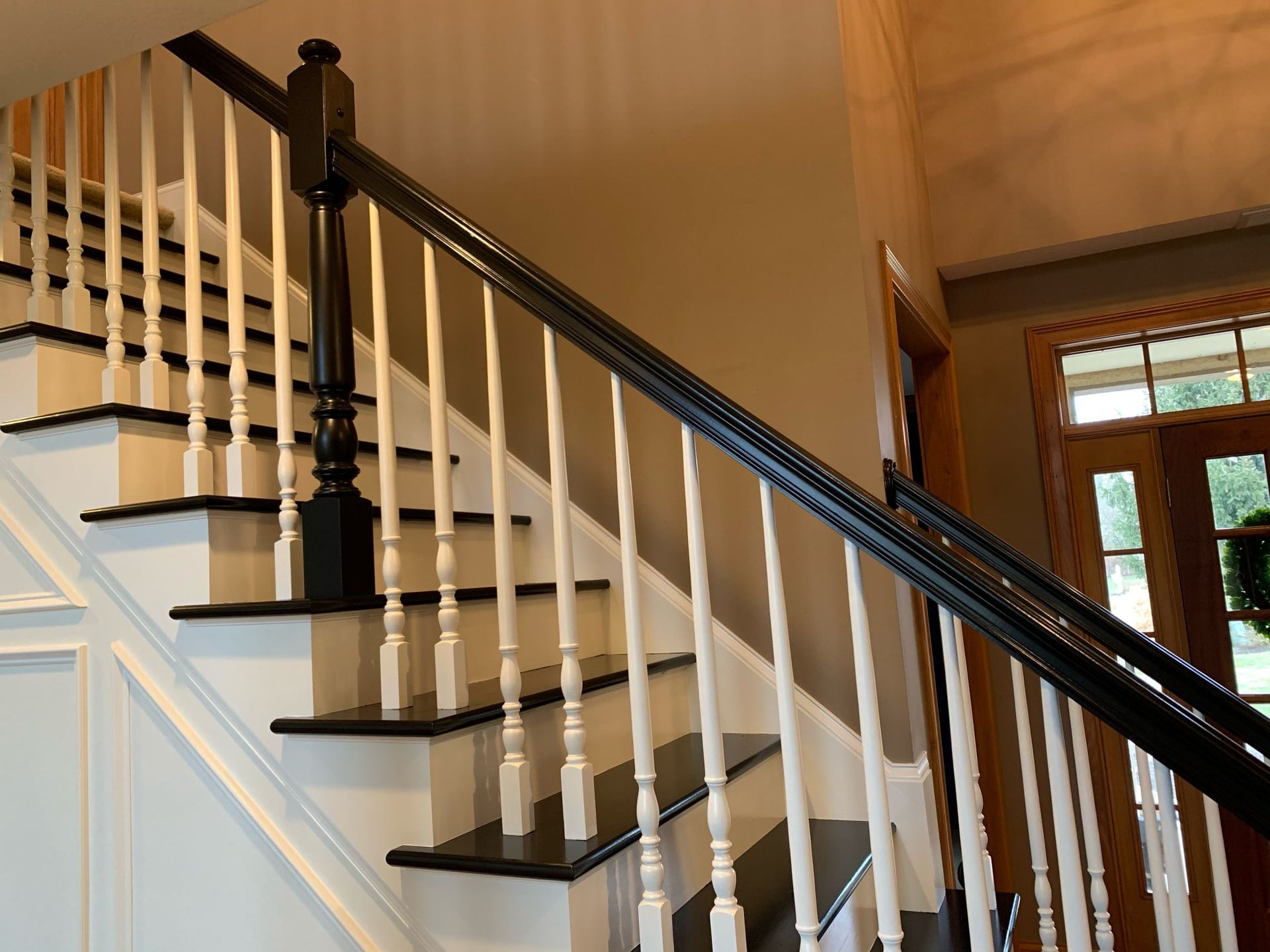 A staircase with a black railing and white steps