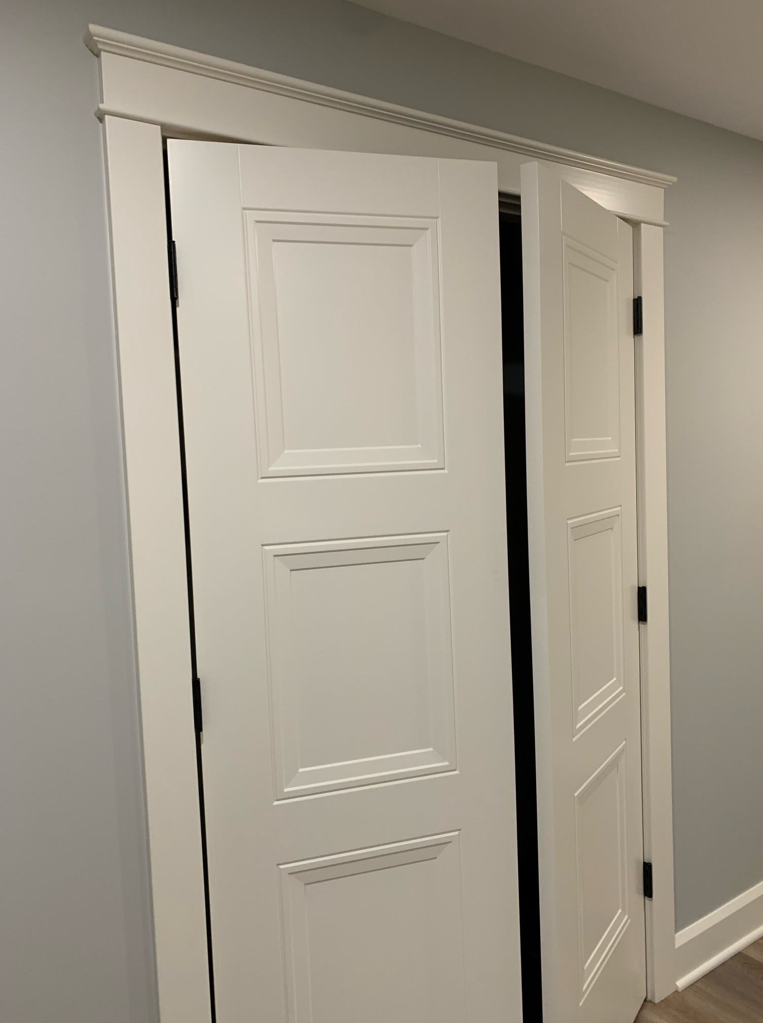 A white door is open in a room with a gray wall.