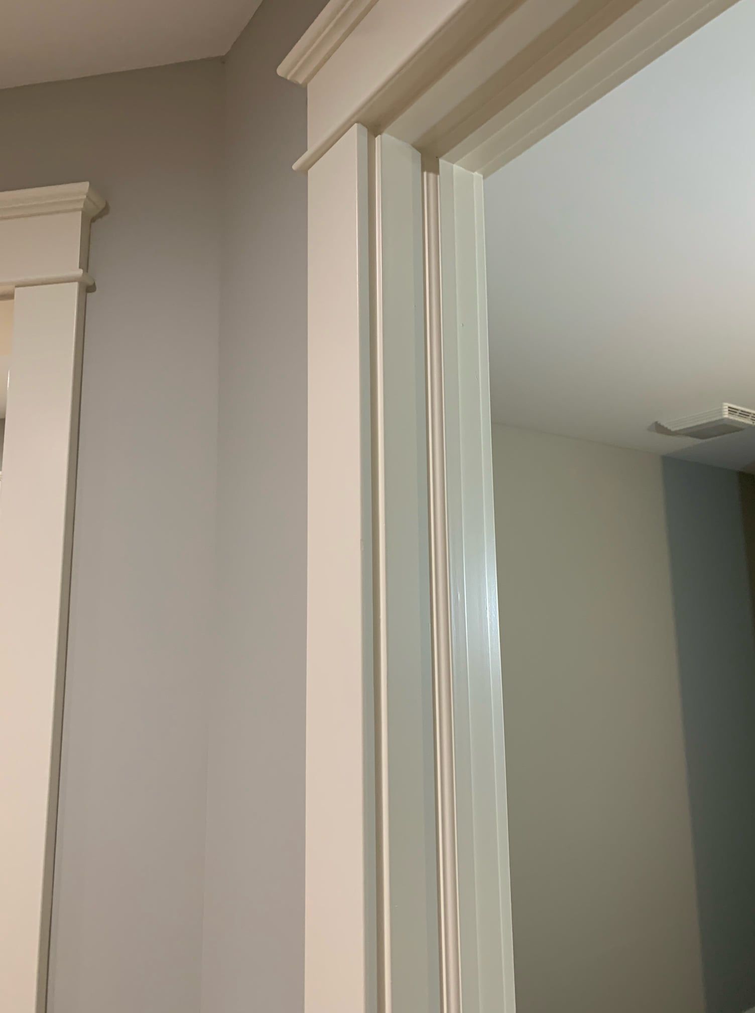 A close up of a door with a white trim in a room.