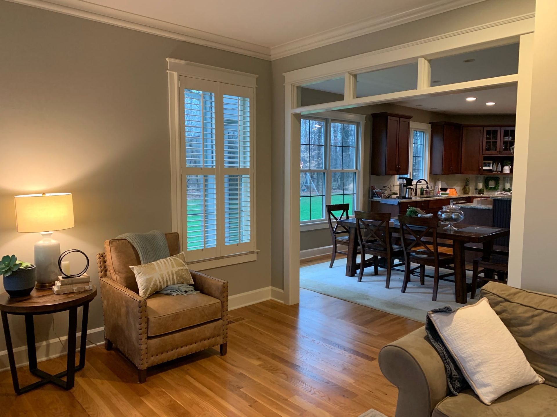 A living room with a couch , chair , table and lamp.
