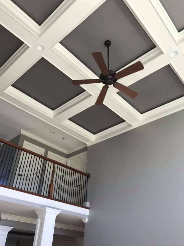 A ceiling fan is hanging from the ceiling of a room with a balcony.