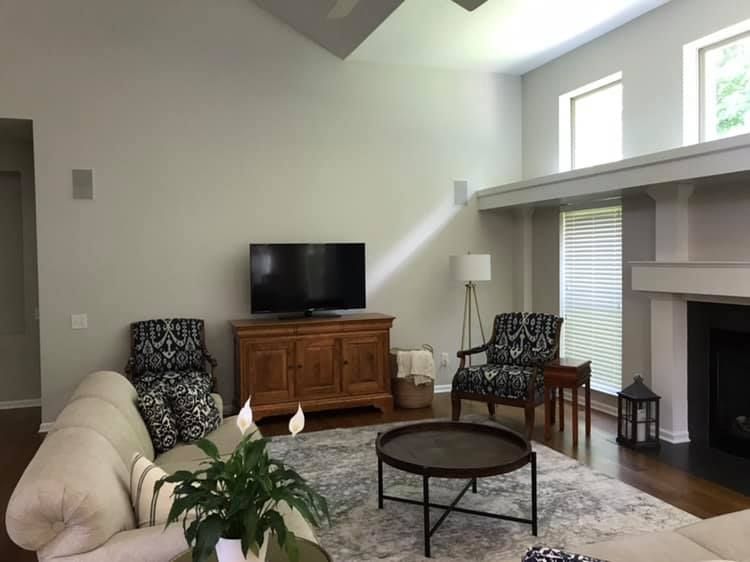 A living room with a couch , chairs , coffee table and television.