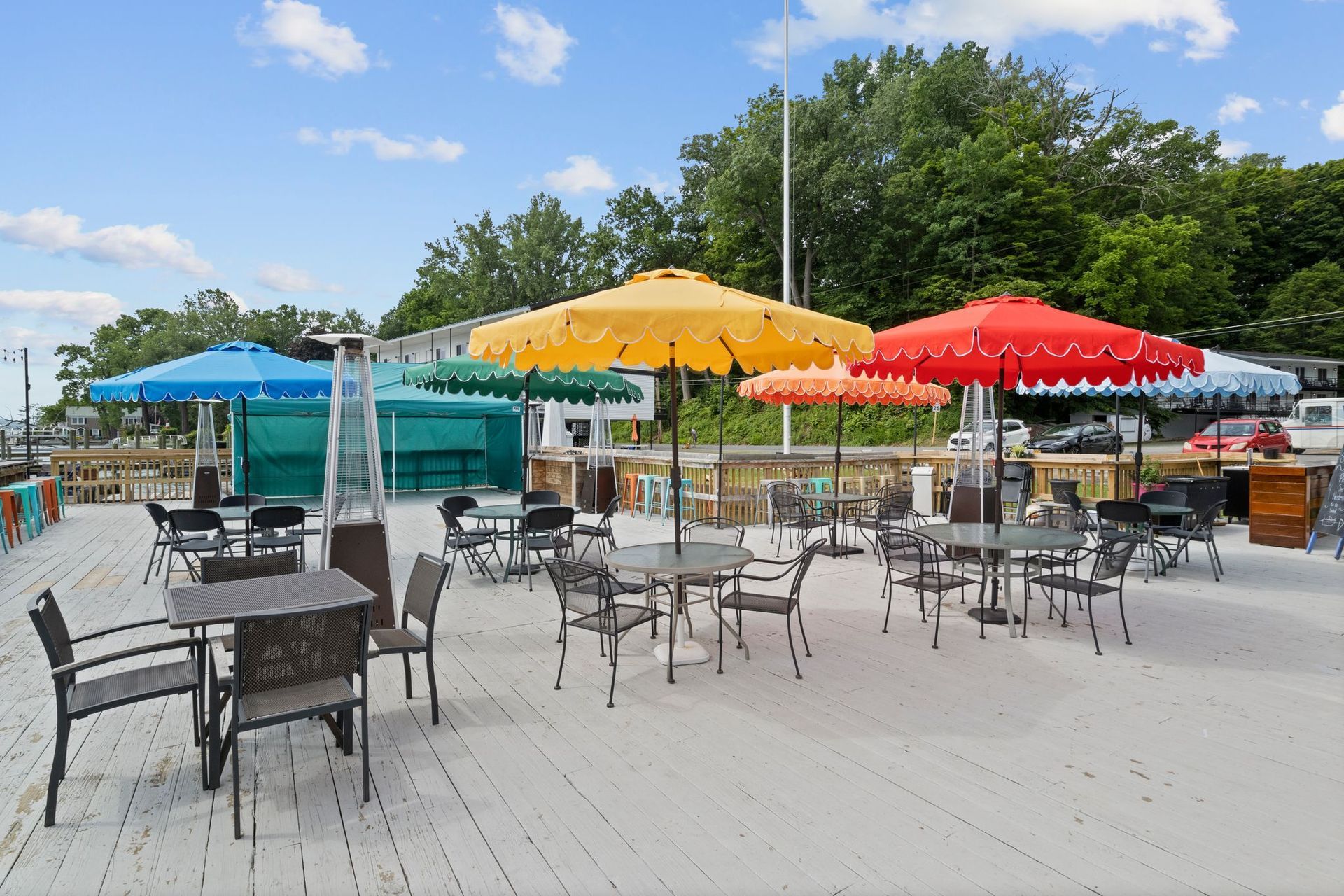 Two white fluffy dogs on leashes with bows, being walked indoors.
