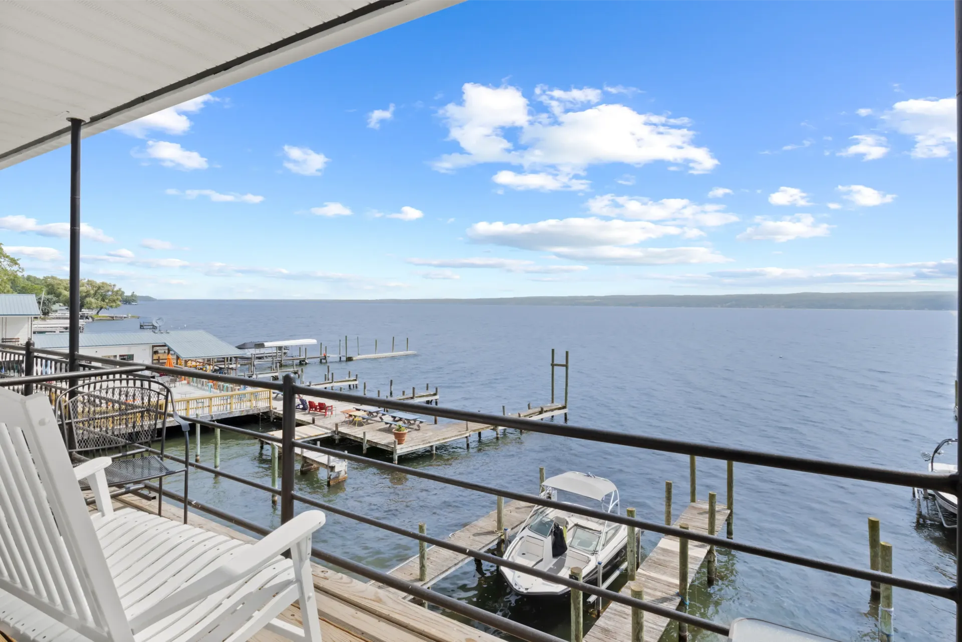 Pool with turquoise water, lounge chairs, and people near a lodge with a mountain backdrop.