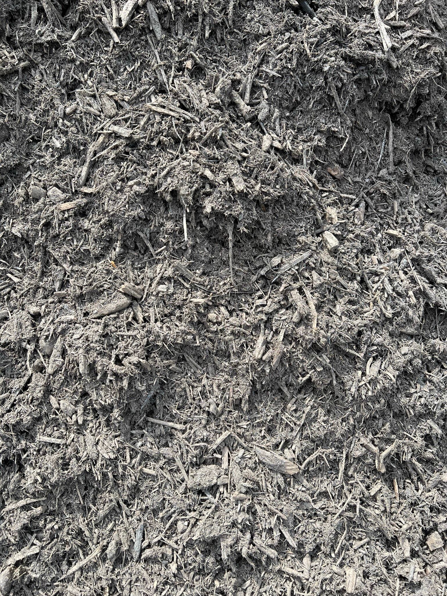 Pile of dark shredded organic material, likely mulch or compost.