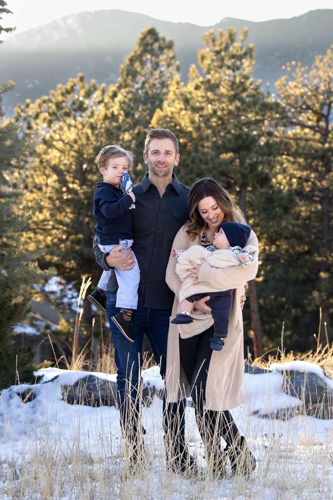 A family is posing for a picture in the snow.