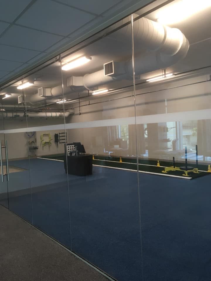 A large room with blue carpet and a glass wall