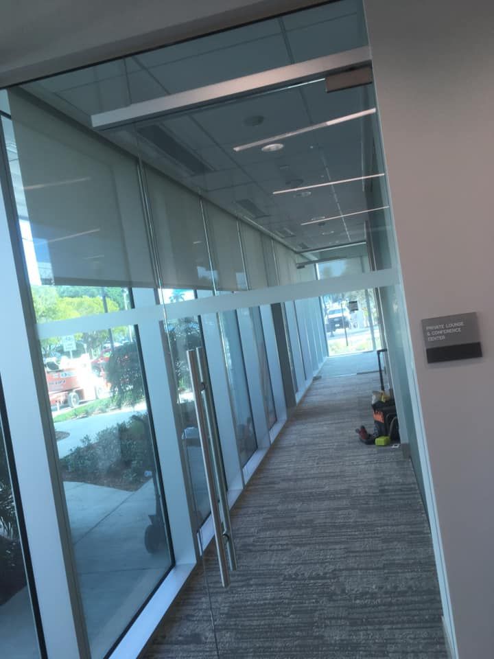A hallway with lots of windows and a sign that says ' office ' on it