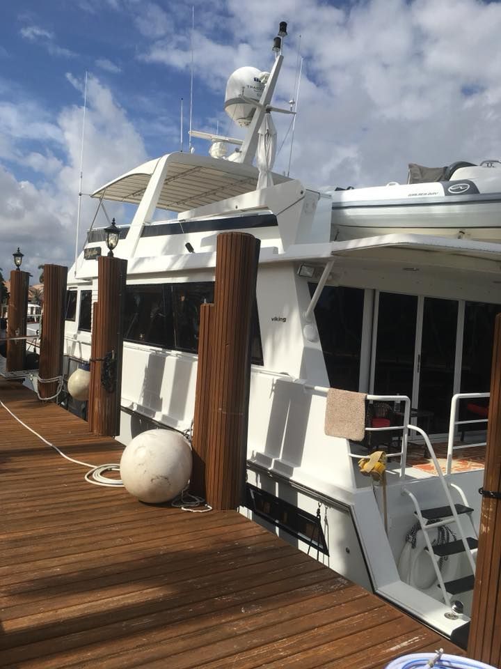 A row of boats are docked at a dock.