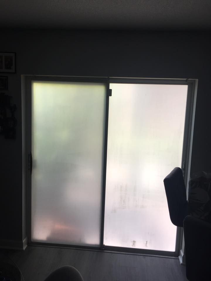 A living room with a sliding glass door and a chair