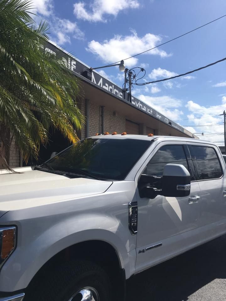 A white truck is parked in front of a building.