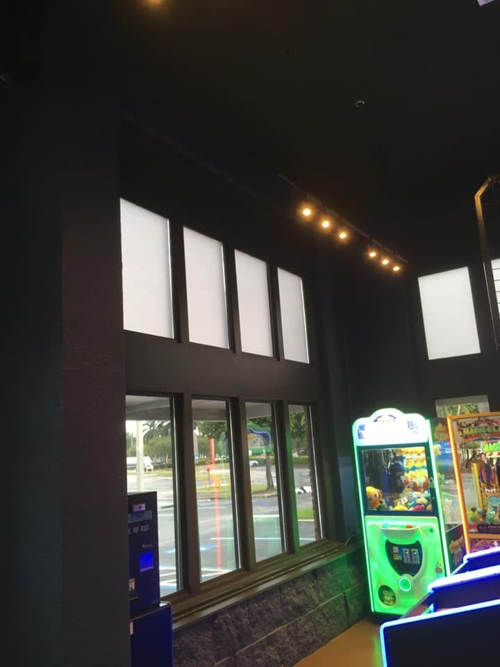 A room with a lot of windows and a green arcade machine
