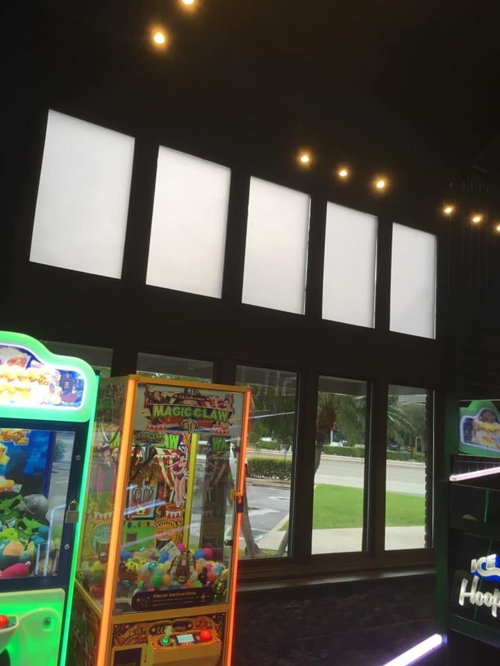 A room with a lot of arcade games and a sign that says hoops