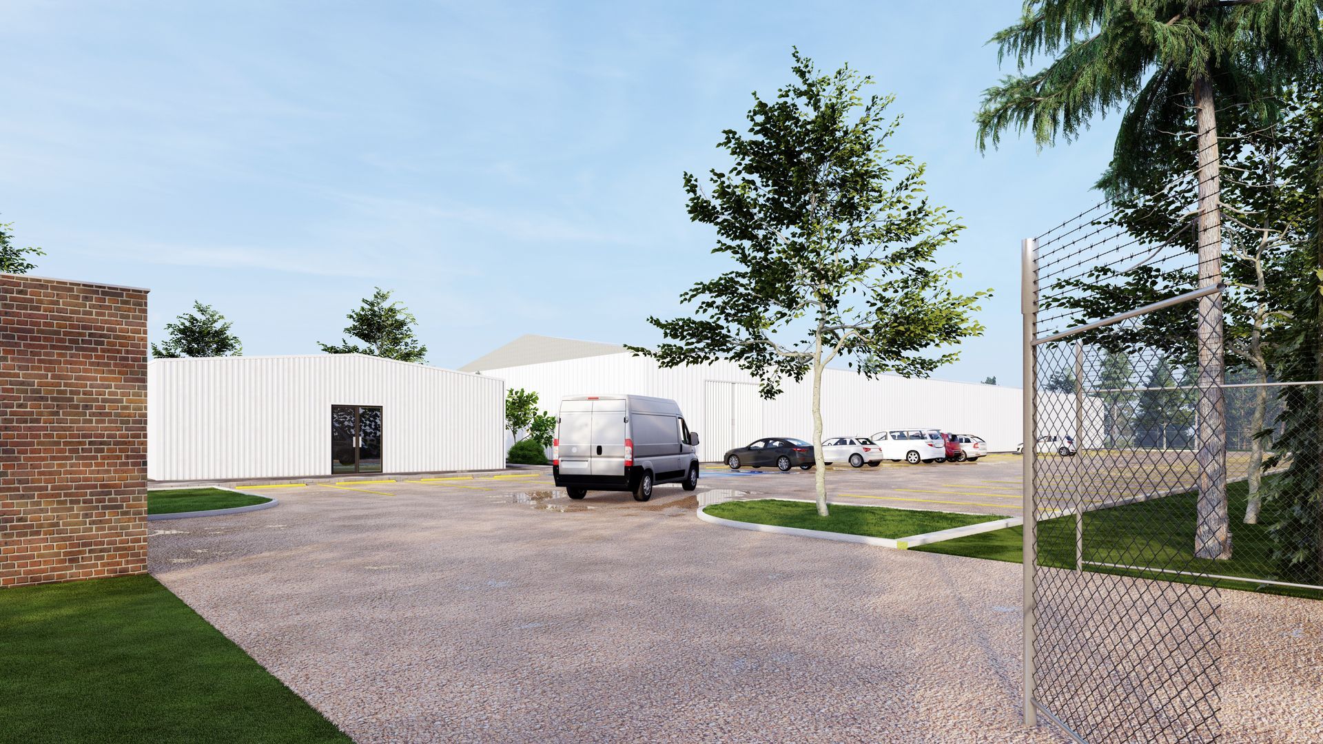 Gravel lot beside white storage buildings, with parked trucks, trees, and a chain-link fence. Gravel lot beside white storage buildings, with parked trucks, trees, and a chain-link fence.