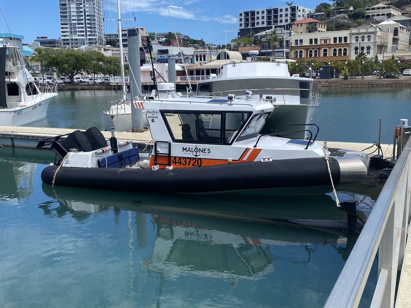 A boat is docked in a harbor next to a dock - Boat Transportation in South Townsville, QLD