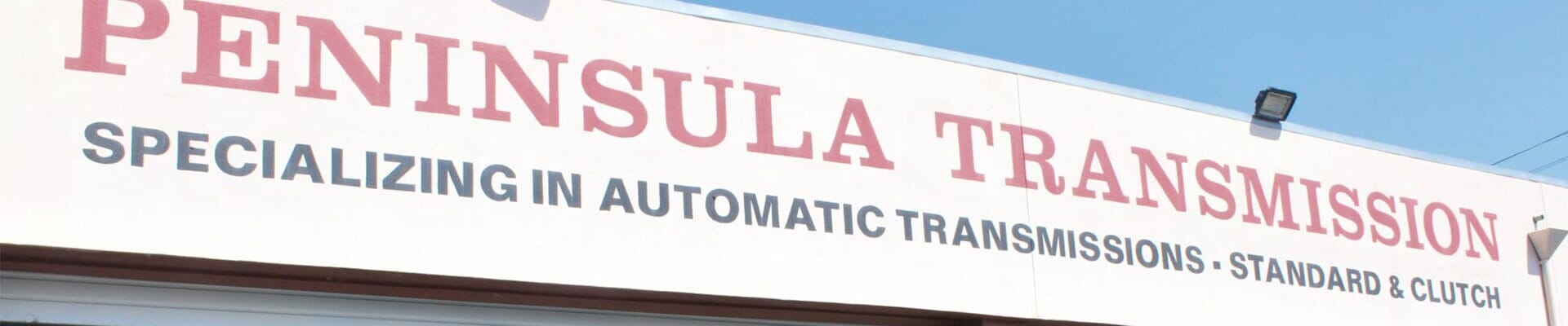 Sign for Peninsula Transmission, specializing in automatic transmissions.