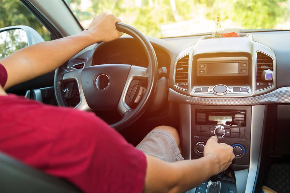 A man is driving a car with his hands on the steering wheel — Marx Forster Tyres & Mechanical In Forster, NSW