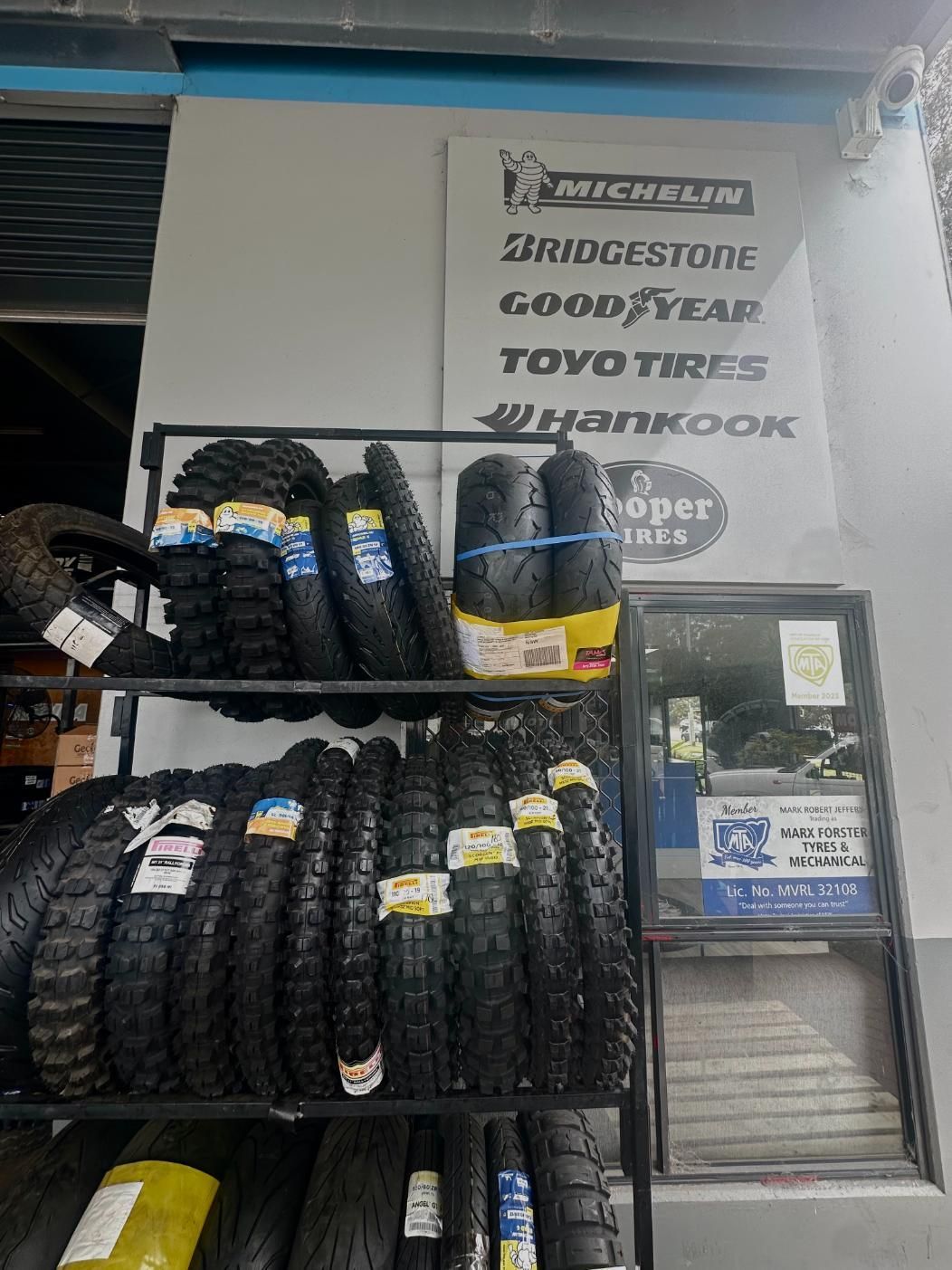 A Bunch of Motorcycle Tyres Are Stacked on Top of Each Other on a Rack — Marx Forster Tyres & Mechanical In Forster, NSW