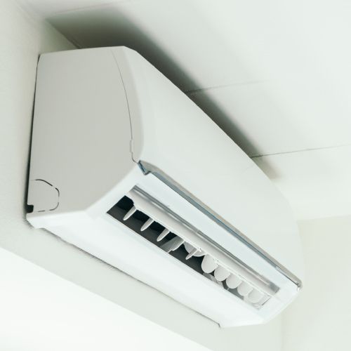 A white air conditioner is hanging from the ceiling