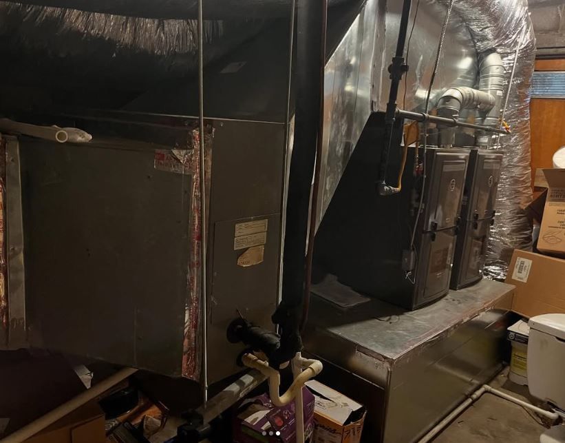 A room with a lot of pipes and boxes on the floor.