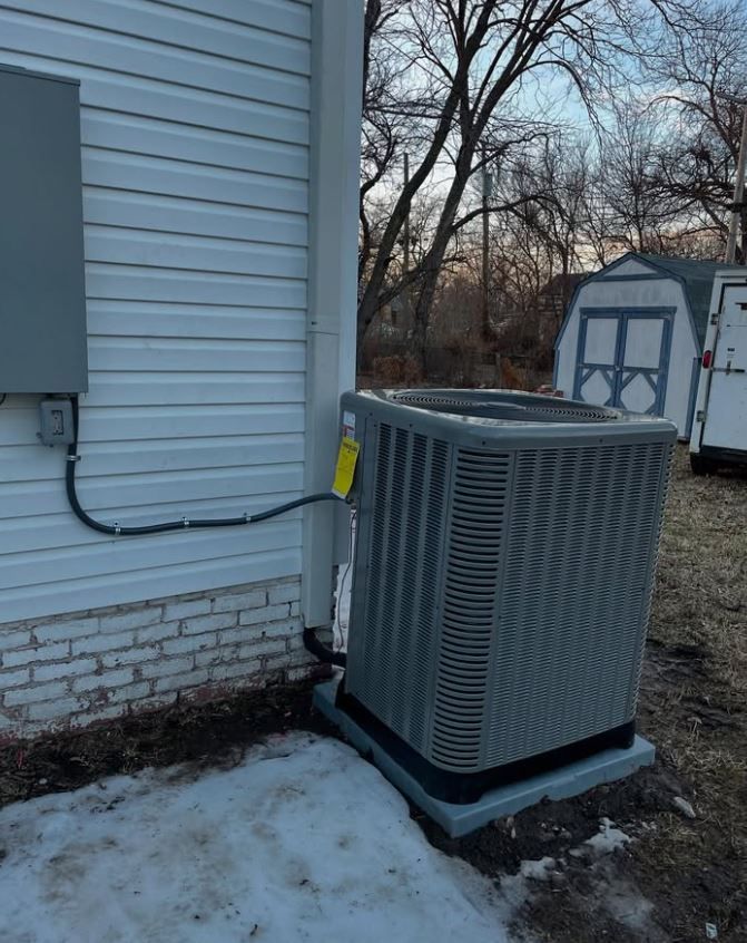 An air conditioner is sitting on the side of a house.