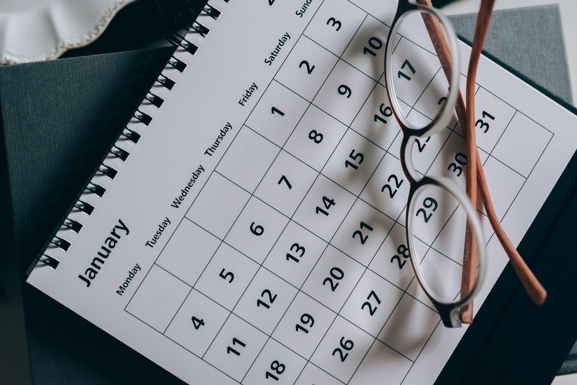 January calendar with eyeglasses and pencil on top