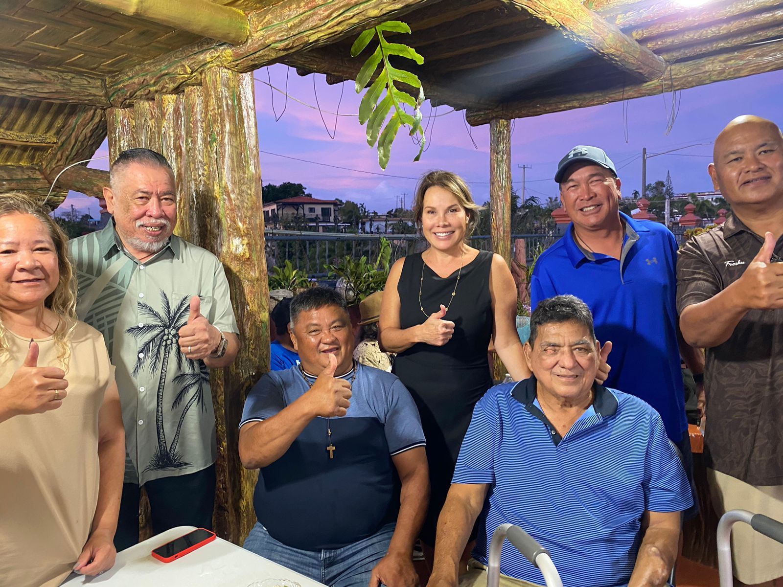 A woman in a red dress stands at a podium in front of an american flag