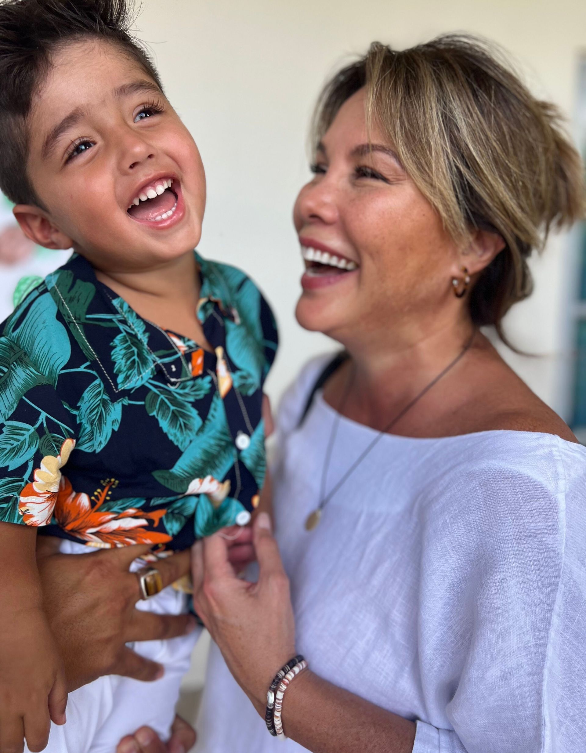 Ginger Cruz is holding a little boy who is smiling