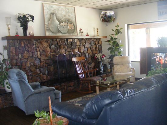 Cozy living room with a stone fireplace, armchairs, and a leather sofa.