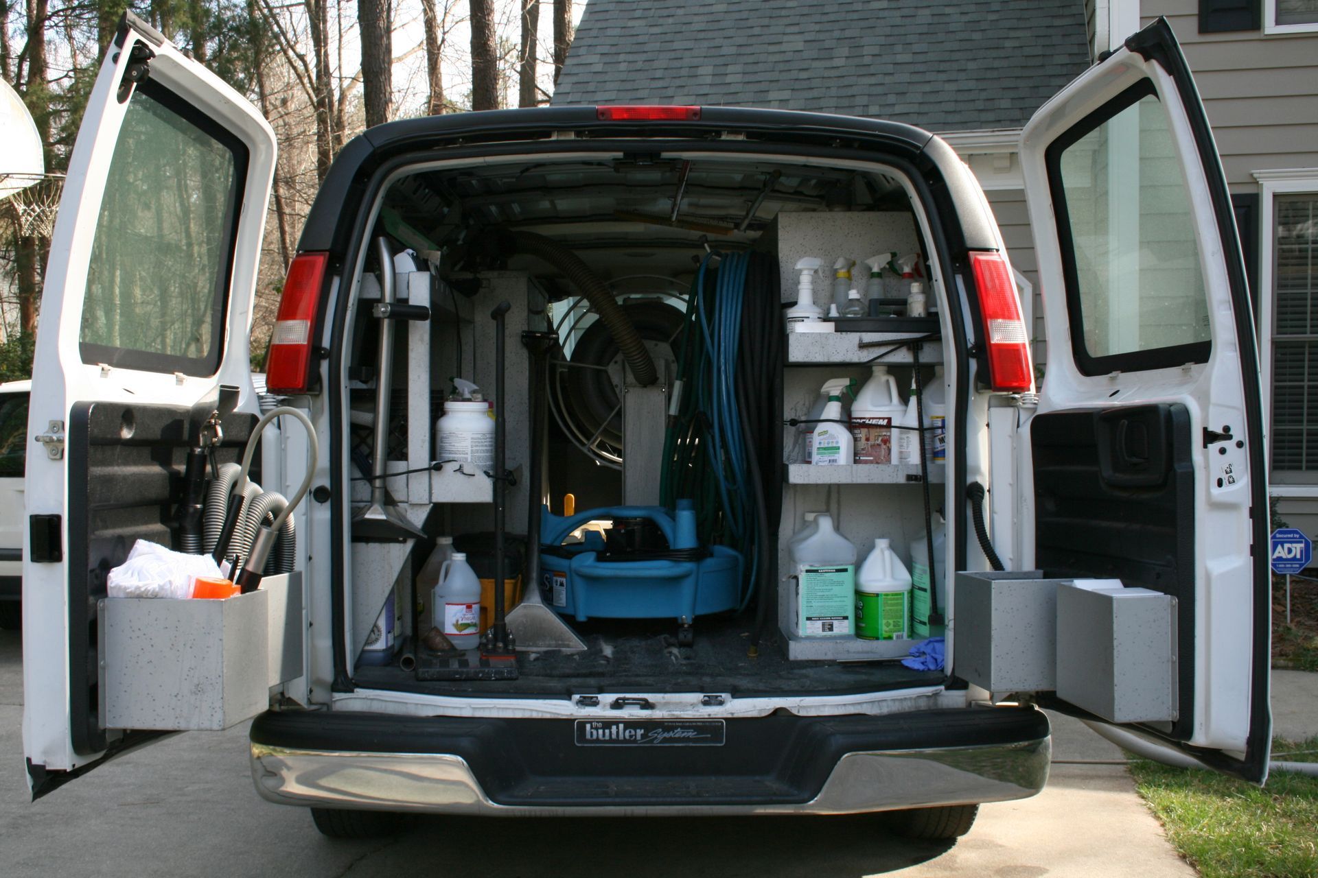 Inside of a white van organized with professional carpet cleaning equipment.