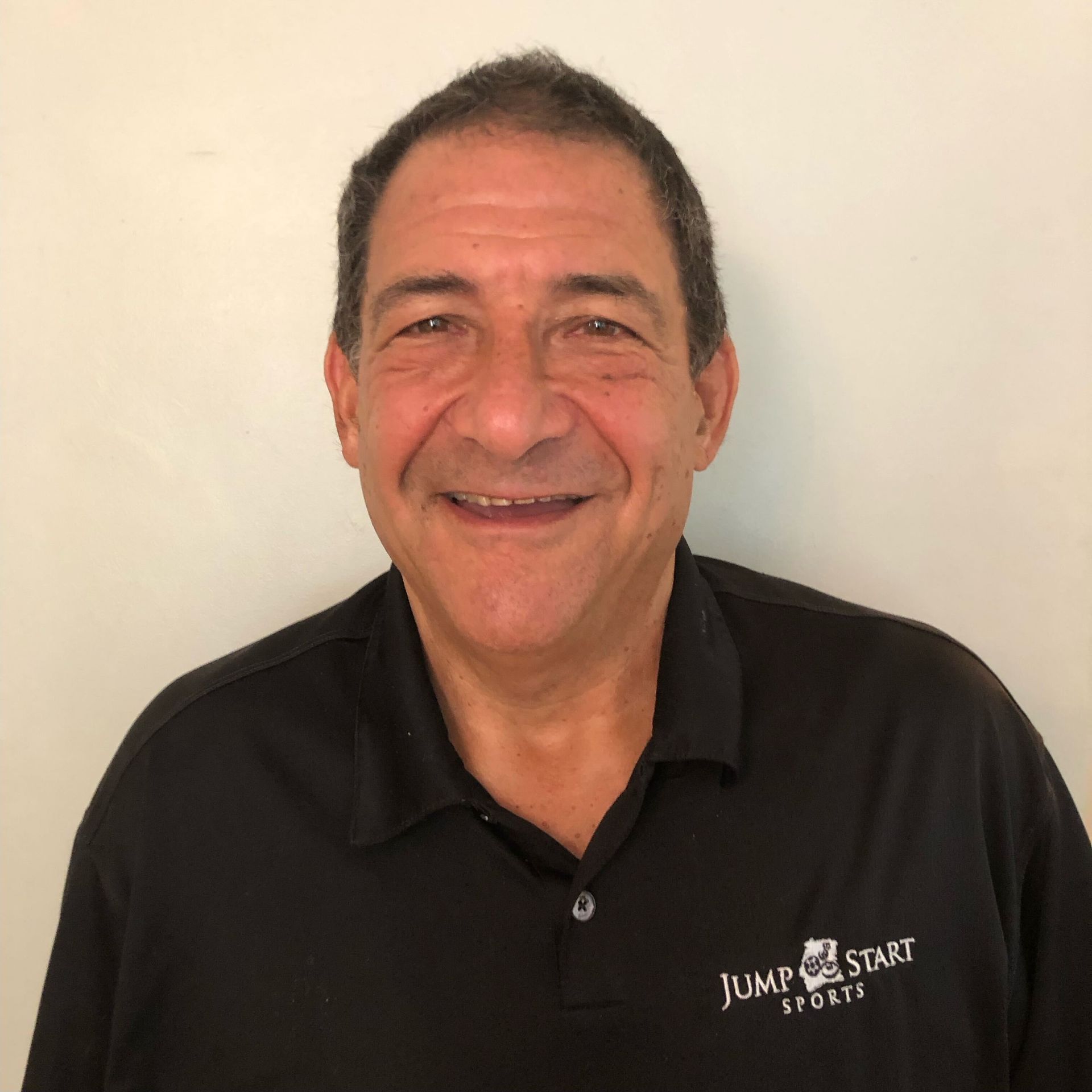 A man in a suit and blue shirt is smiling for the camera.