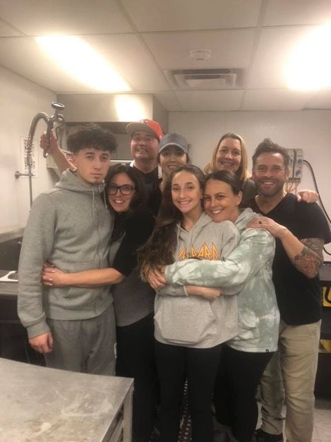 A group of people are posing for a picture in a kitchen.