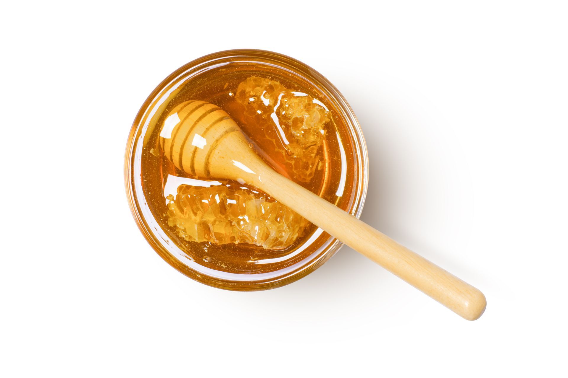 Una ciotola di miele con dentro un mestolo di legno.
