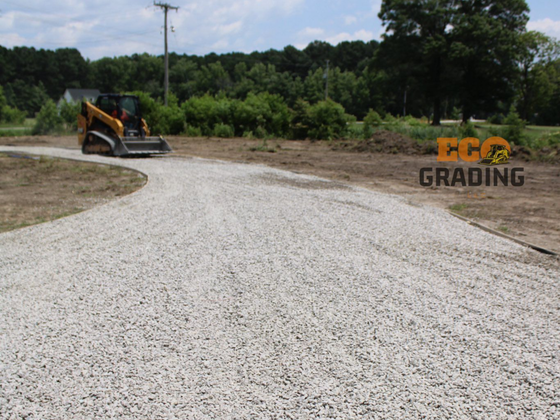 Earthmoving equipment working on a construction site in Youngsville, NC. Dirt and trees are visible.