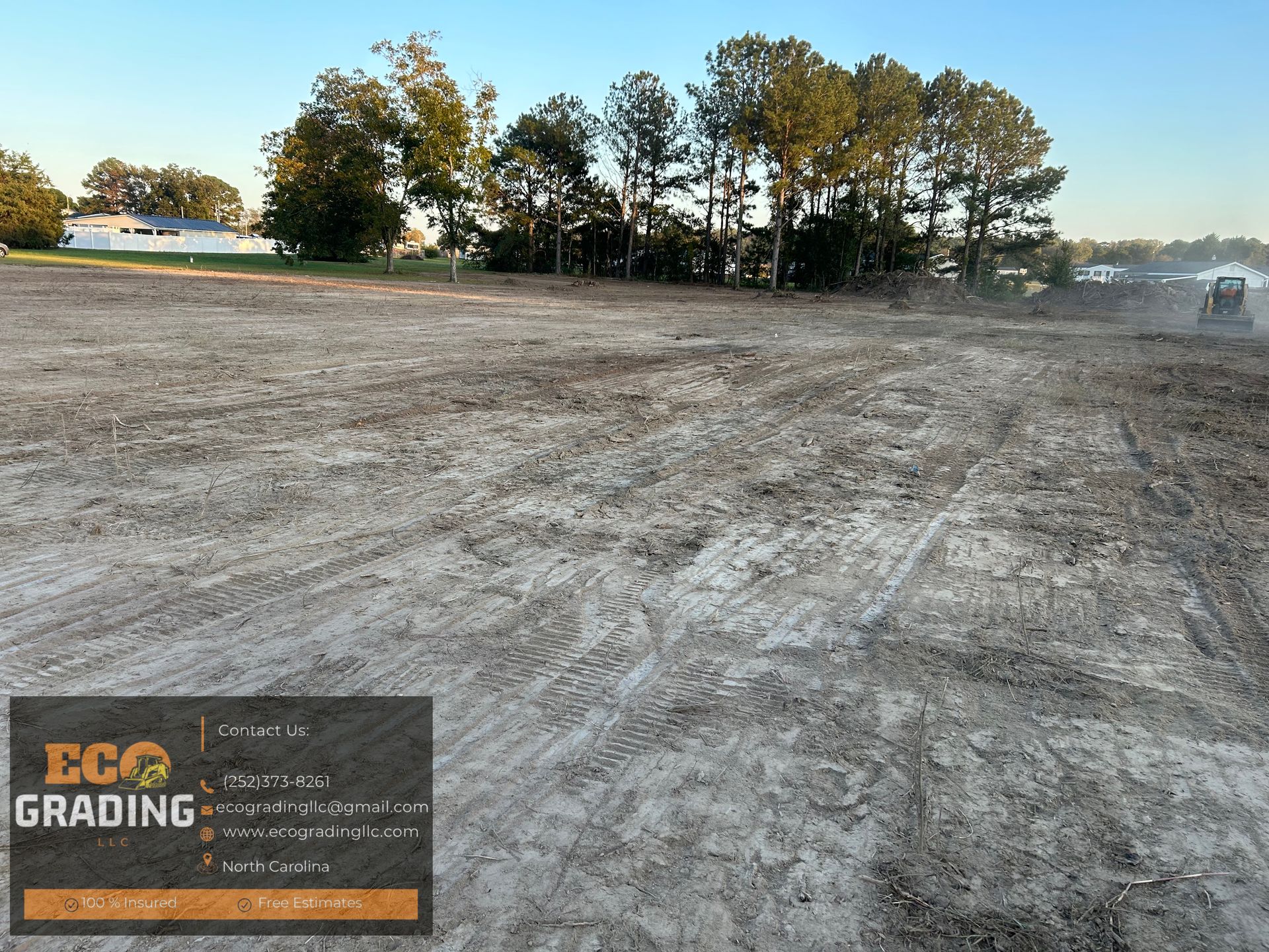 Graded dirt lot with trees in the background, ECO GRADING logo in the corner.