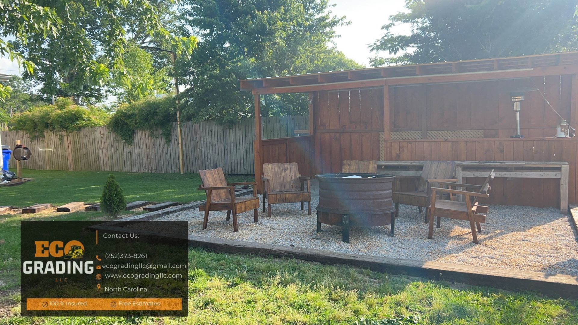 Backyard patio with wooden structure, seating, and gravel flooring.