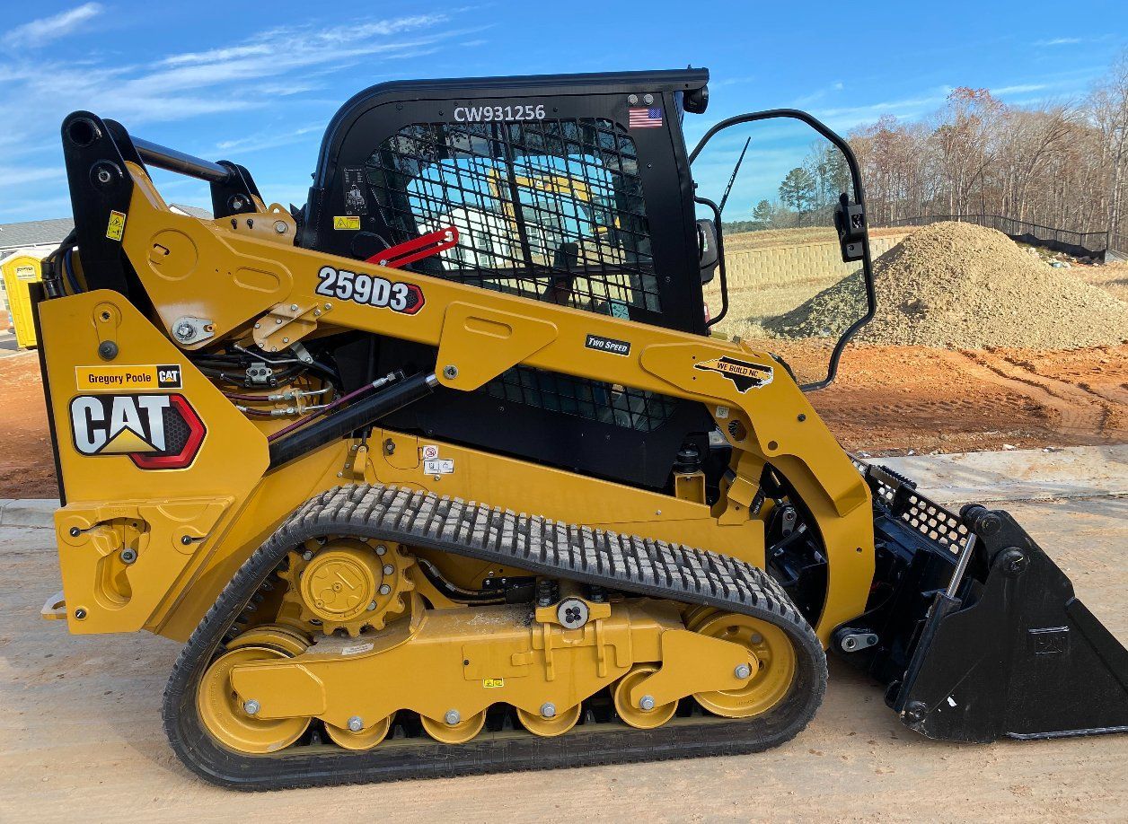 Yellow Caterpillar 259D3 compact track loader on a construction site.