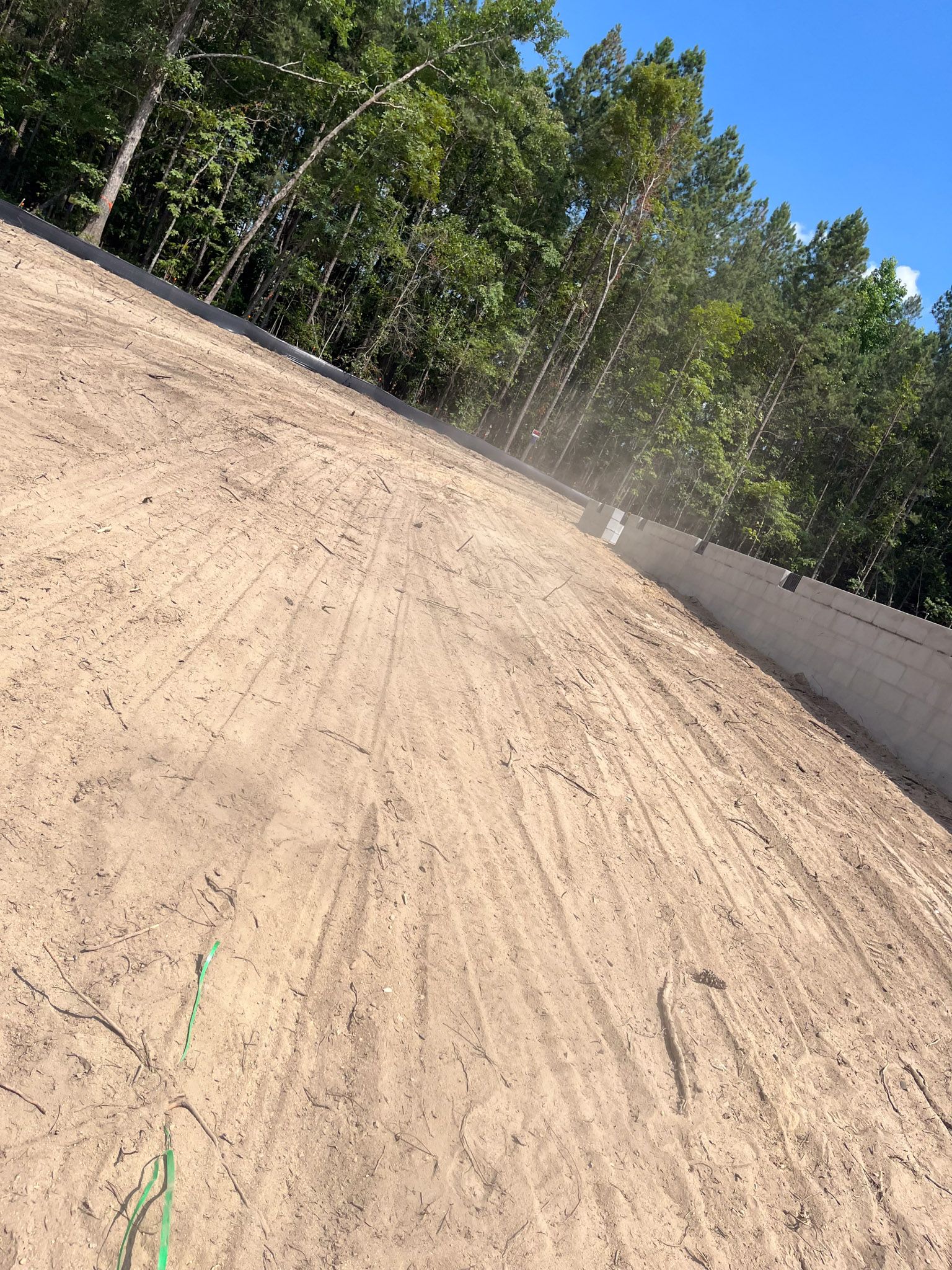 Dirt ramp with trees in background, likely a motocross track.
